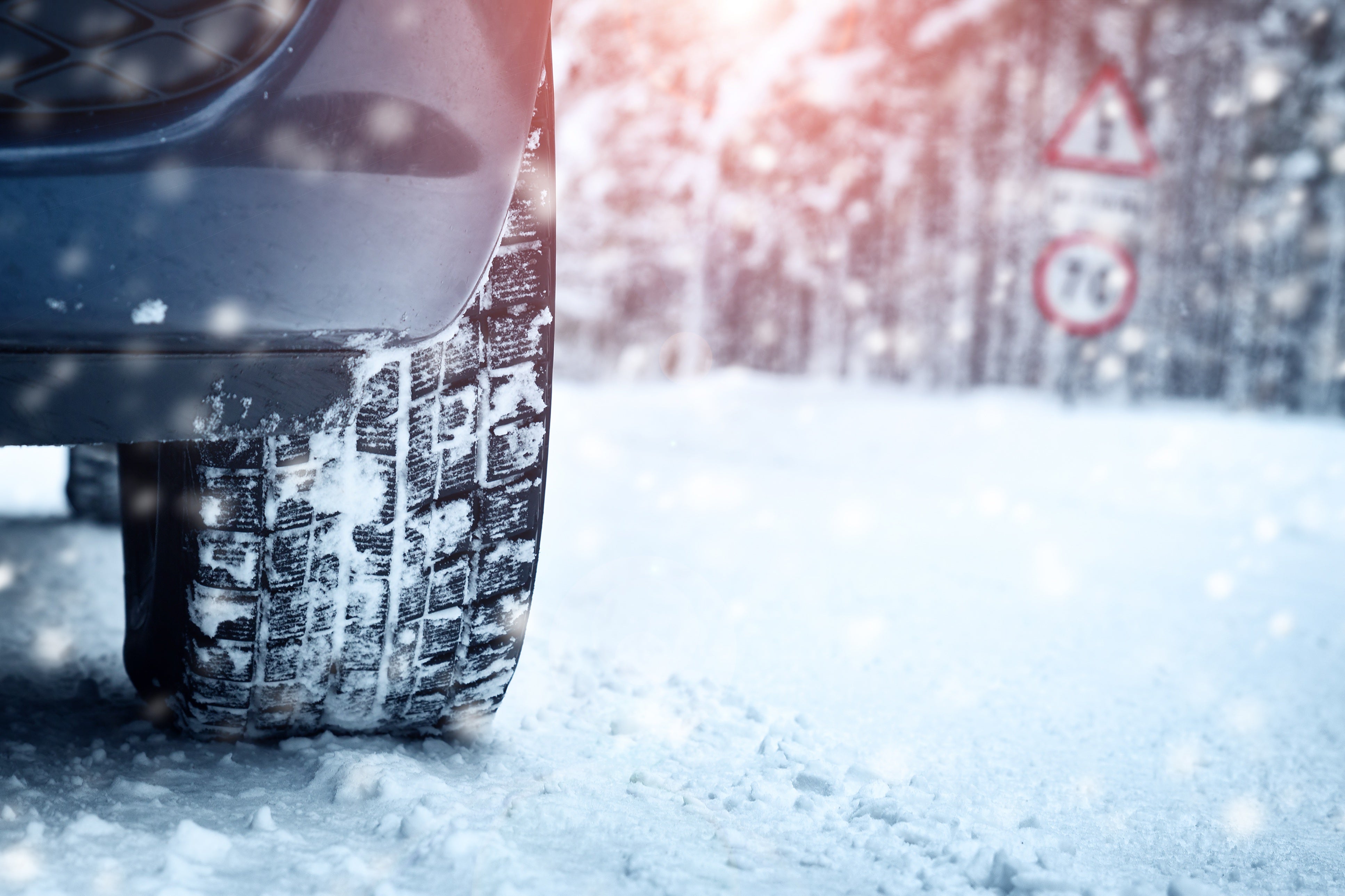 Vehicle tire driving on a snowy road with winter conditions